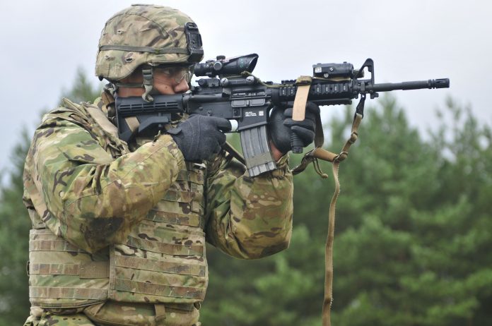 Image via Popular Mechanics, Soldier with an M4A1 5.56x45mm carbine